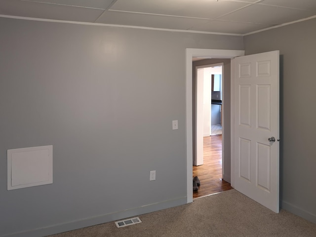 empty room with carpet flooring, visible vents, and baseboards