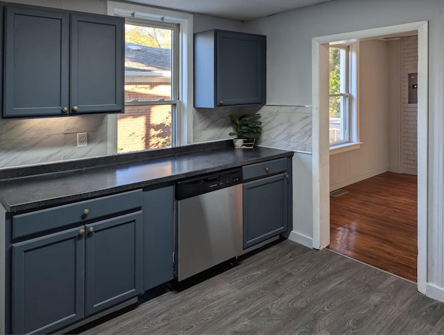 kitchen with dark countertops, dark wood-style flooring, dishwasher, and backsplash