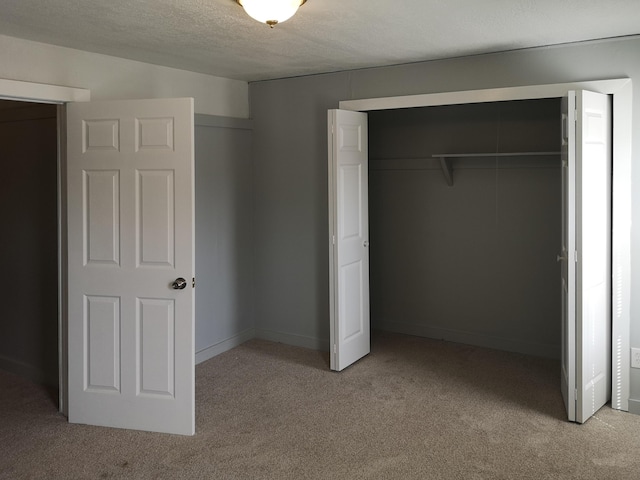 unfurnished bedroom with a closet, carpet flooring, and a textured ceiling