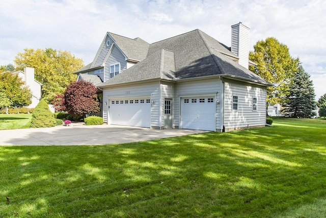 view of side of home featuring a garage, a shingled roof, driveway, a lawn, and a chimney