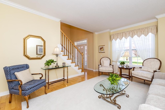 living area with ornamental molding, wood finished floors, baseboards, and stairs