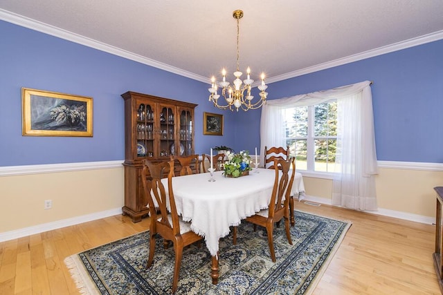 dining area featuring a chandelier, light wood-type flooring, ornamental molding, and baseboards