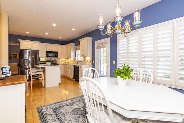 dining room with a chandelier, recessed lighting, and light wood finished floors