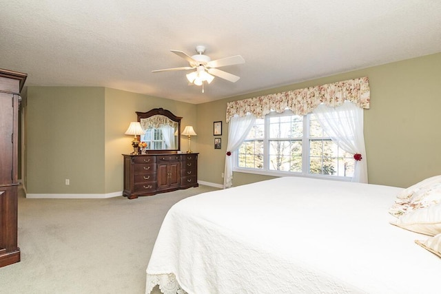 bedroom with light carpet, ceiling fan, baseboards, and a textured ceiling