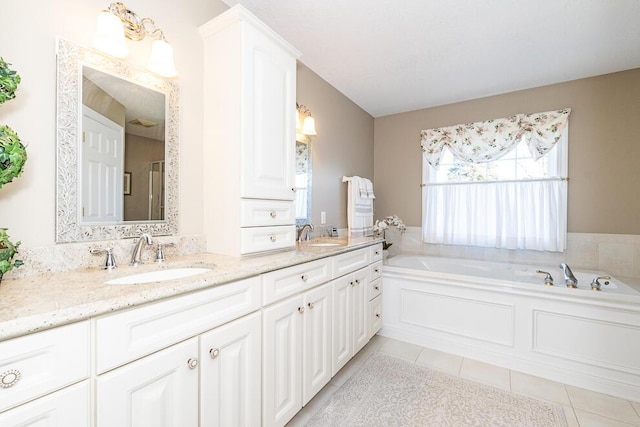 full bath with double vanity, a sink, a bath, and tile patterned floors