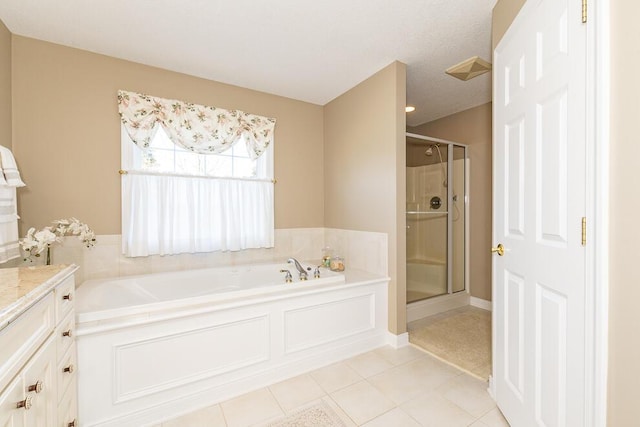 full bath featuring a stall shower, a garden tub, vanity, and tile patterned floors