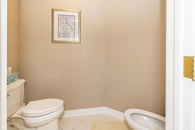 half bathroom featuring baseboards, toilet, and tile patterned floors