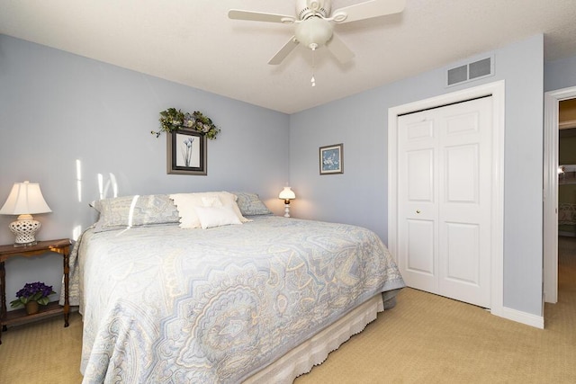 carpeted bedroom featuring baseboards, a closet, visible vents, and a ceiling fan