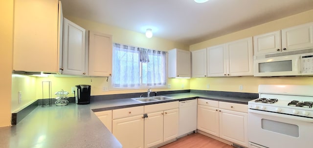 kitchen featuring white cabinets, white appliances, and a sink