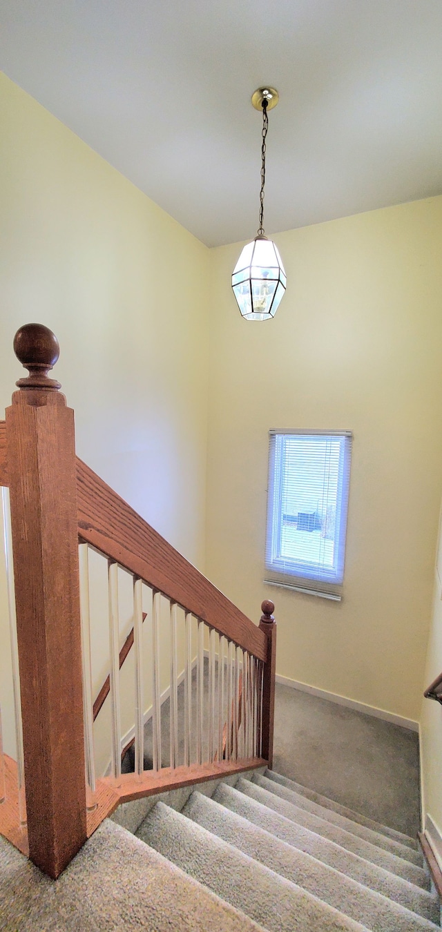 stairs featuring baseboards and carpet flooring