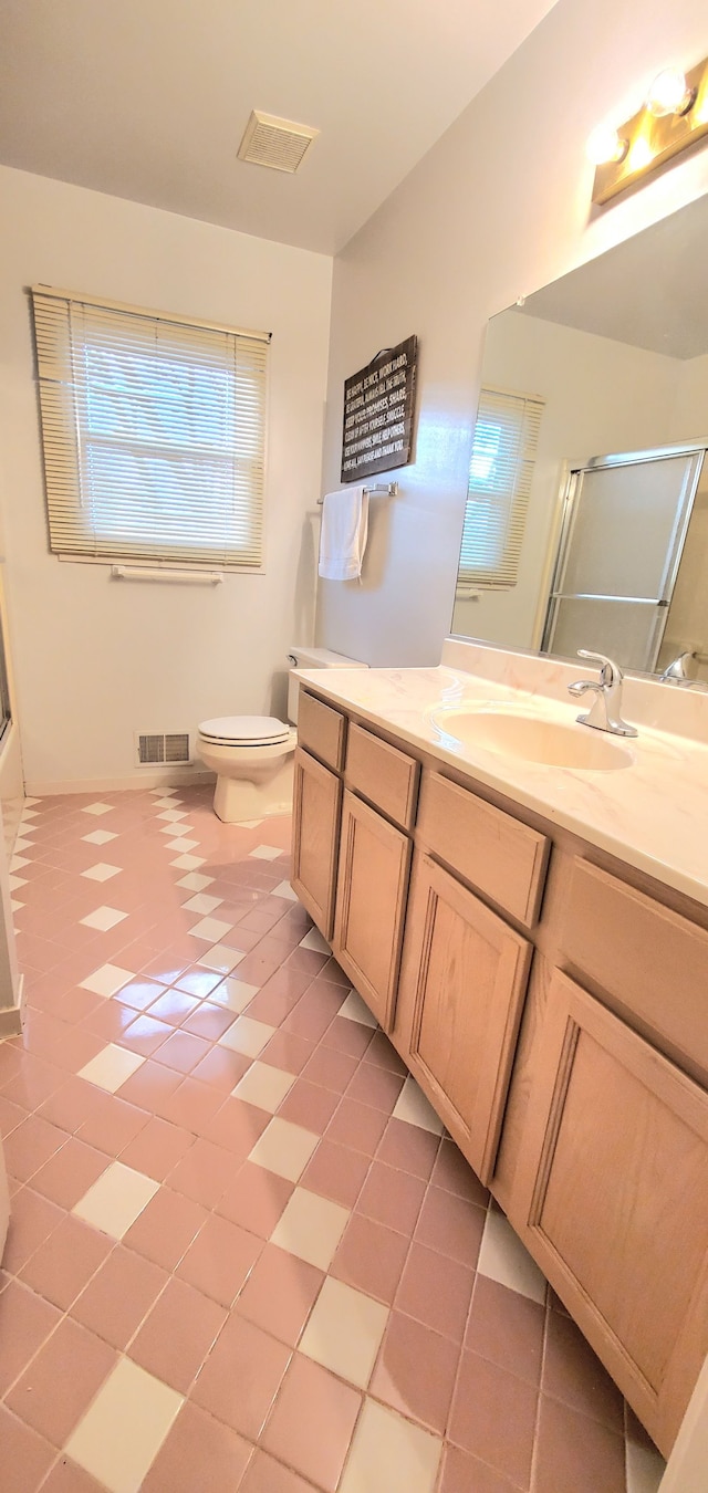 full bath with vanity, visible vents, and a shower with shower door