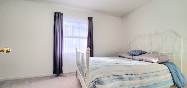 bedroom featuring visible vents, light colored carpet, and baseboards