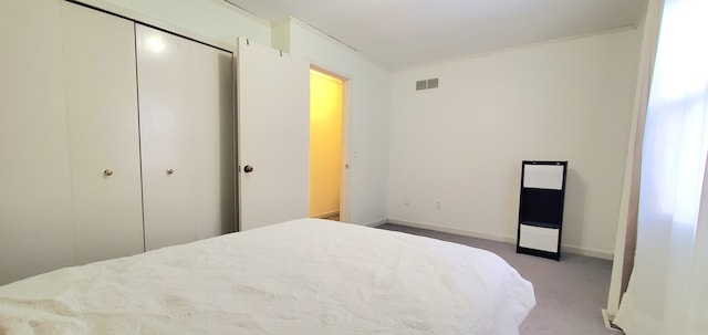 bedroom with light colored carpet, visible vents, a closet, and baseboards