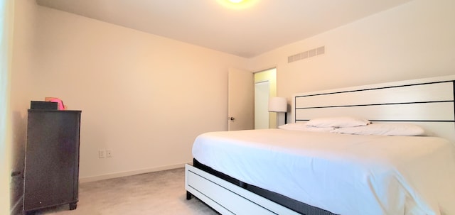 bedroom featuring visible vents, light carpet, and baseboards