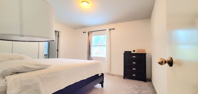 bedroom featuring light colored carpet and baseboards