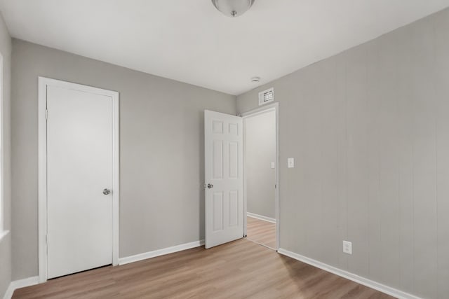 unfurnished bedroom featuring light wood-style floors, baseboards, and visible vents