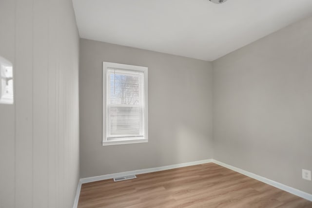 unfurnished room with visible vents, light wood-style flooring, and baseboards