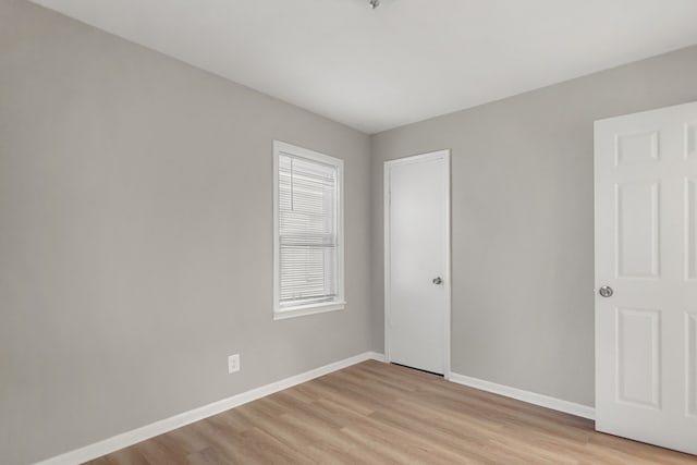 unfurnished bedroom with light wood-type flooring and baseboards