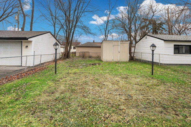 view of yard with a garage, a storage unit, an outdoor structure, and fence