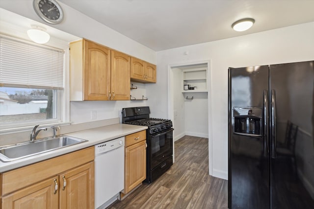 kitchen featuring dark wood-style floors, light countertops, a sink, black appliances, and baseboards