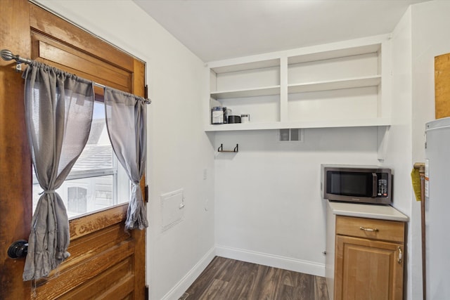 laundry room featuring dark wood-style floors, visible vents, and baseboards