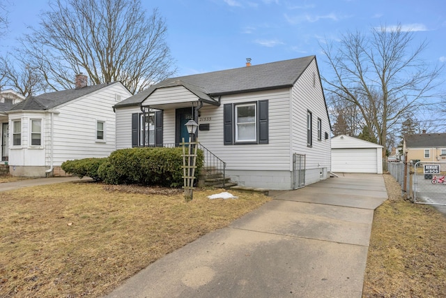 bungalow-style house featuring a garage, a shingled roof, an outdoor structure, a gate, and a front lawn