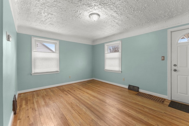 entrance foyer with a wealth of natural light, light wood-style flooring, and baseboards