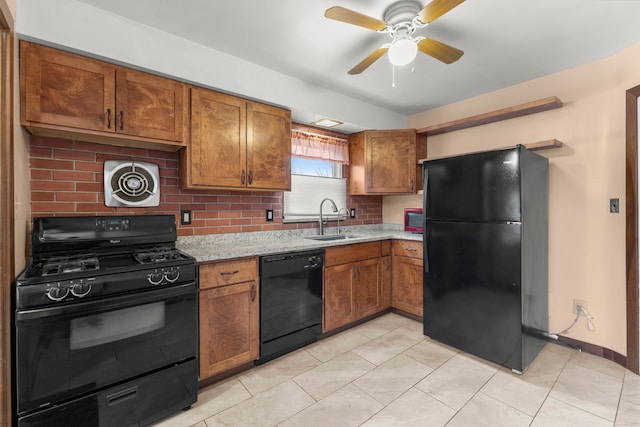 kitchen featuring tasteful backsplash, brown cabinets, a sink, and black appliances