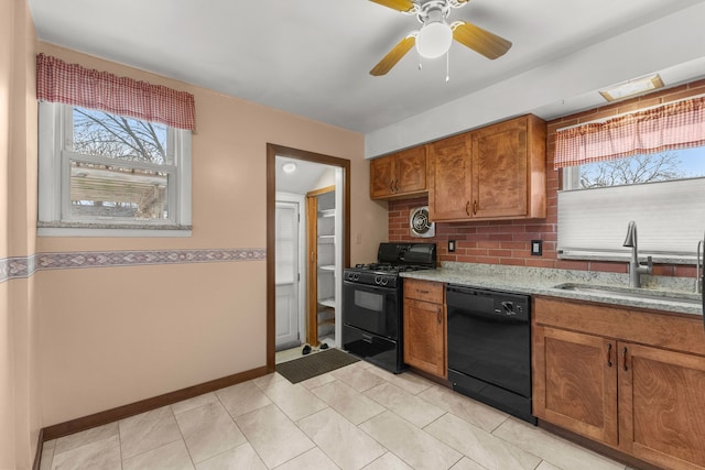 kitchen with brown cabinetry, a healthy amount of sunlight, a sink, and black appliances