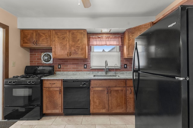 kitchen featuring tasteful backsplash, visible vents, brown cabinets, black appliances, and a sink