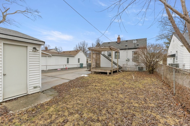 rear view of house featuring a chimney, fence, a patio area, central AC, and a pergola