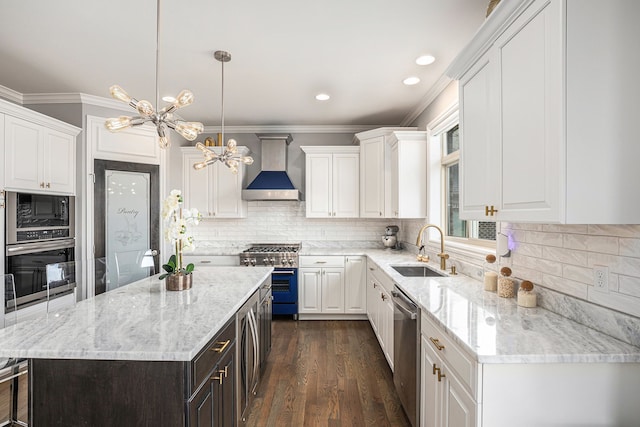 kitchen featuring white cabinets, wall chimney exhaust hood, stainless steel appliances, and a sink