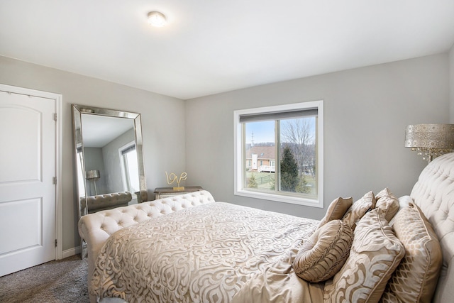 bedroom with baseboards and dark colored carpet