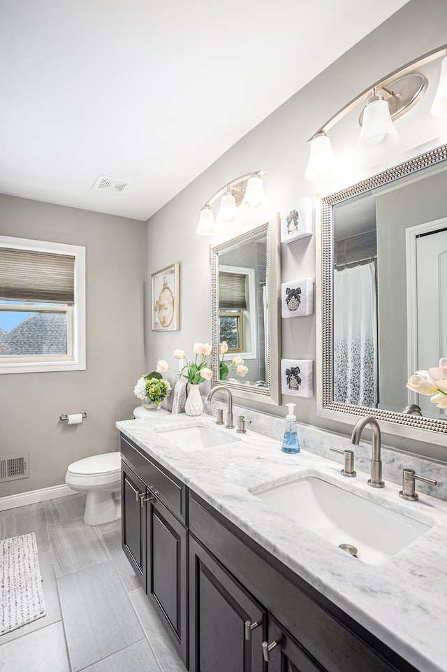 full bathroom with toilet, a sink, and visible vents