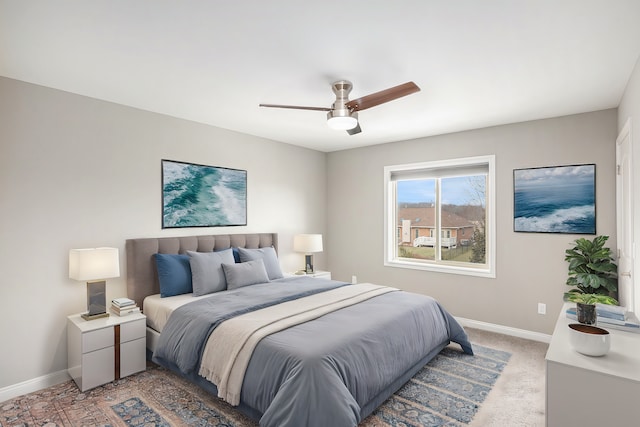 bedroom with light colored carpet, ceiling fan, and baseboards