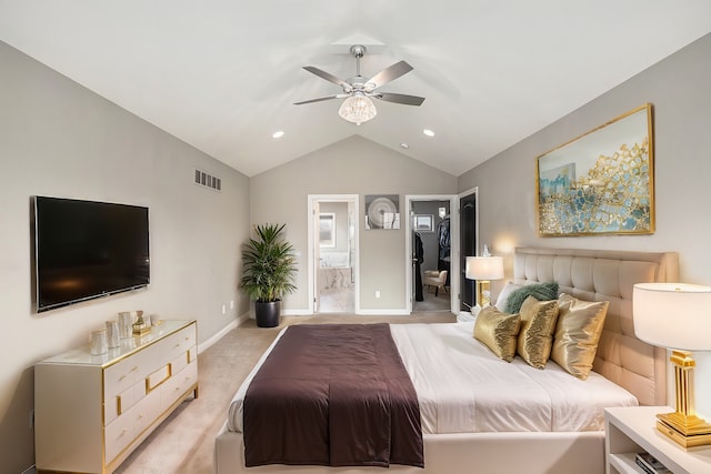 bedroom featuring a walk in closet, lofted ceiling, light colored carpet, visible vents, and connected bathroom