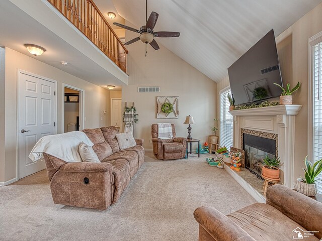 living room with visible vents, a ceiling fan, carpet, a fireplace, and high vaulted ceiling