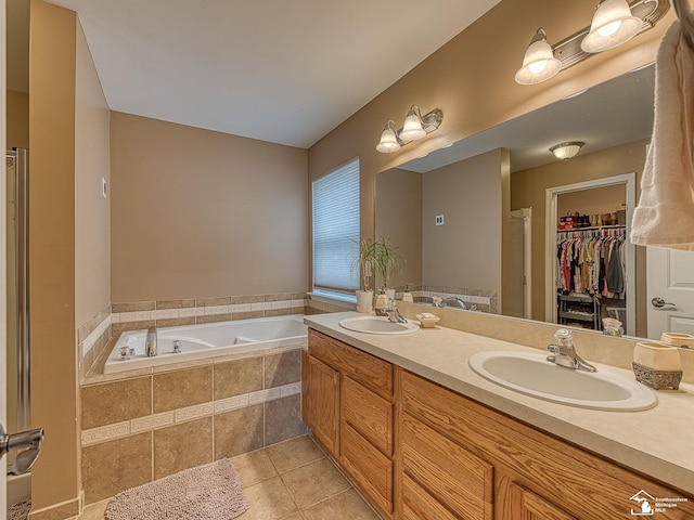 full bathroom featuring a spacious closet, tile patterned flooring, a sink, and a bath