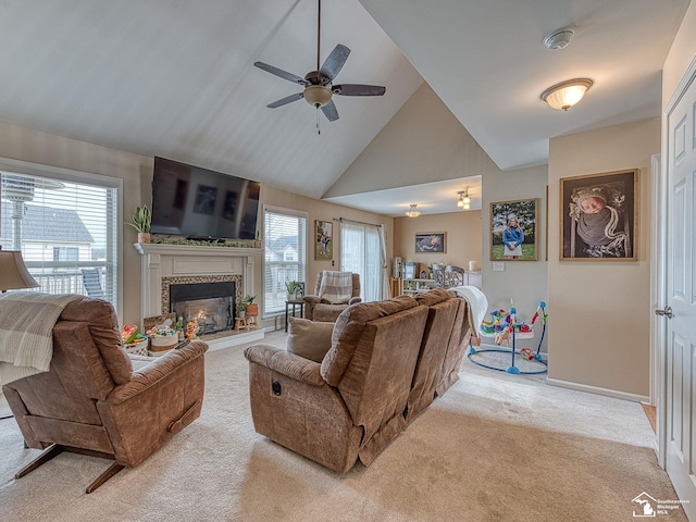 carpeted living area featuring plenty of natural light, high vaulted ceiling, a ceiling fan, and a tile fireplace