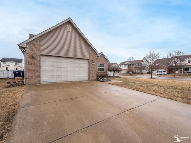 view of home's exterior featuring concrete driveway, brick siding, an attached garage, and a residential view