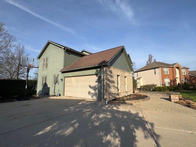 1085 Melrose Ct, Saline, MI 48176 - view of side of home featuring a garage, brick siding, and concrete driveway