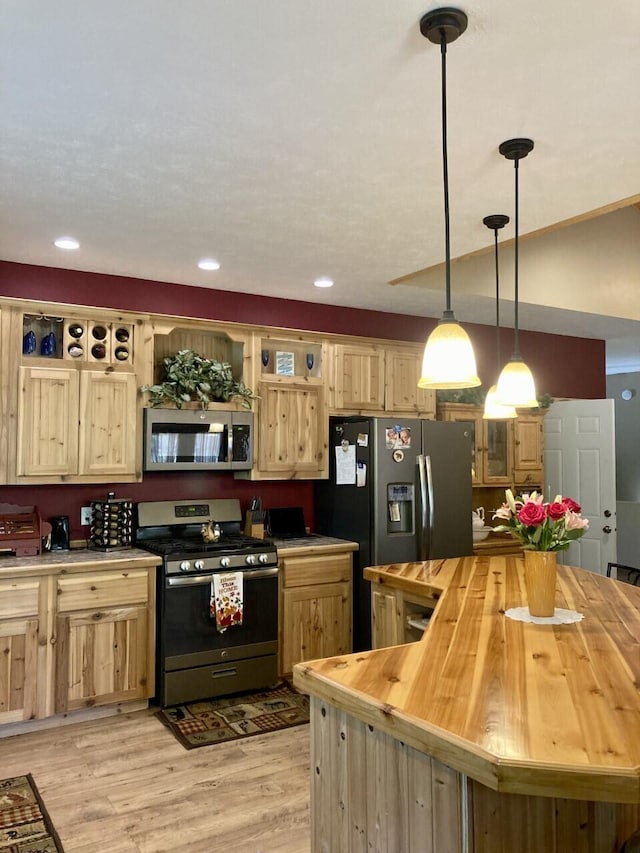 kitchen featuring light brown cabinets, butcher block countertops, light wood-style floors, appliances with stainless steel finishes, and open shelves