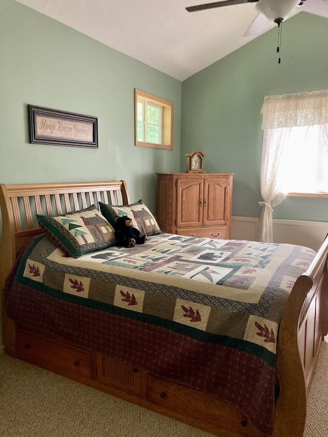 carpeted bedroom with a ceiling fan and vaulted ceiling