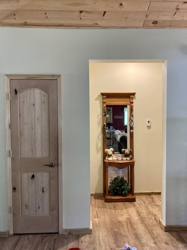hall featuring wood finished floors and baseboards