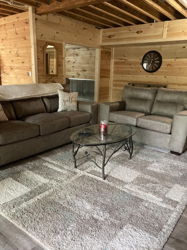 living area featuring wood walls, wood finished floors, and beam ceiling