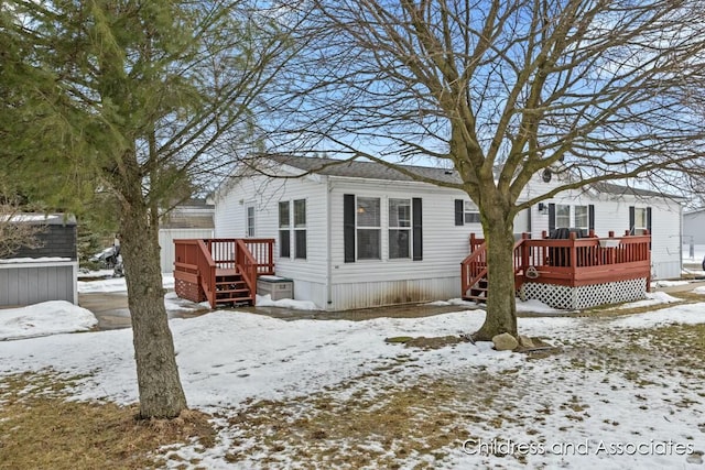 view of snowy exterior with a wooden deck