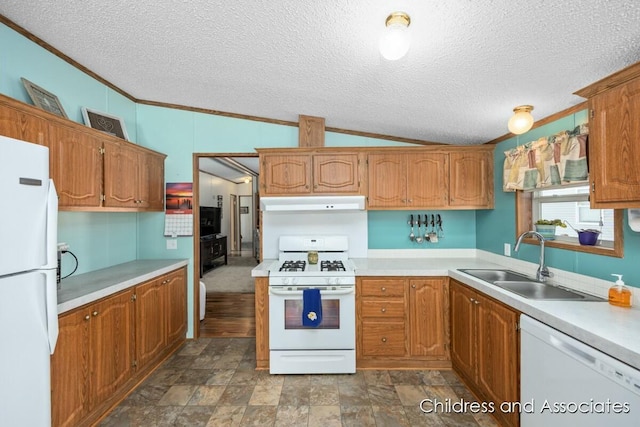 kitchen with under cabinet range hood, white appliances, a sink, vaulted ceiling, and light countertops