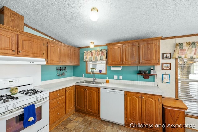 kitchen with white appliances, under cabinet range hood, light countertops, and a sink