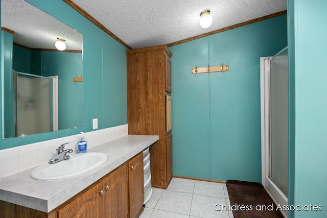 bathroom featuring ornamental molding, a shower stall, vanity, a textured ceiling, and tile patterned floors