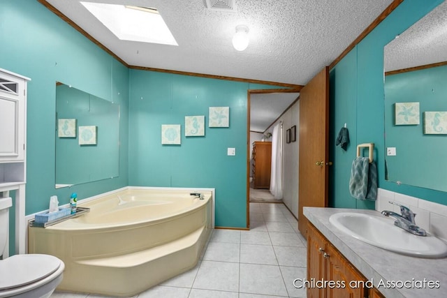 full bathroom featuring a skylight, a garden tub, tile patterned flooring, a textured ceiling, and vanity